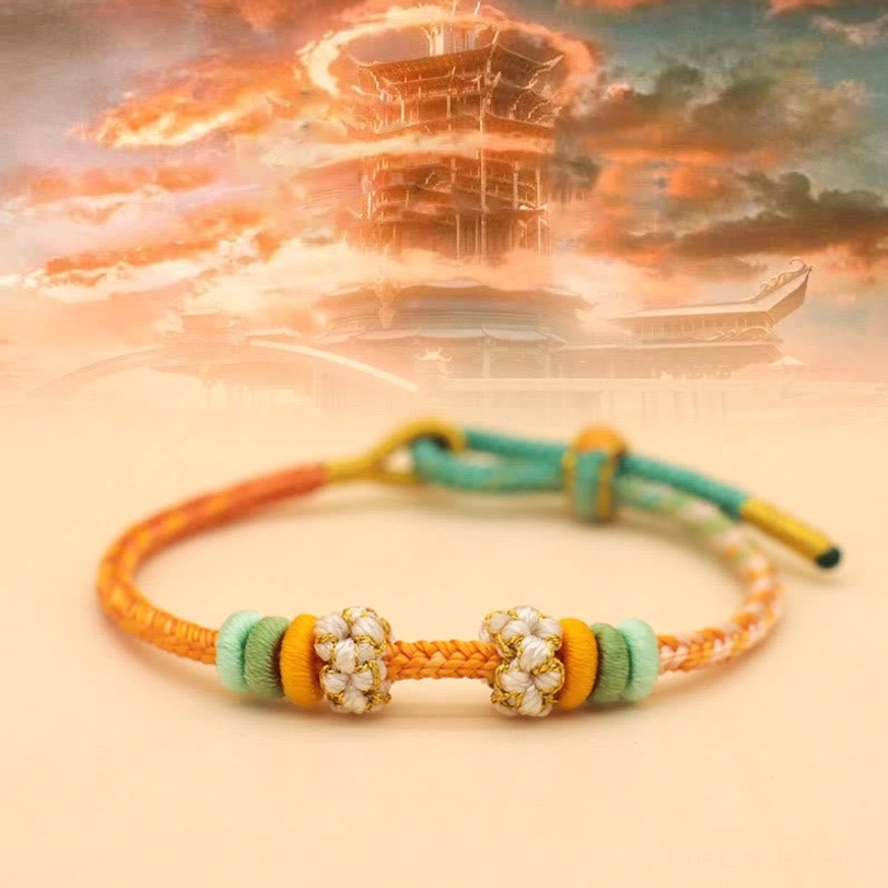 Autumn-toned braided peace knot bracelet featuring orange and teal colors with floral and decorative accents