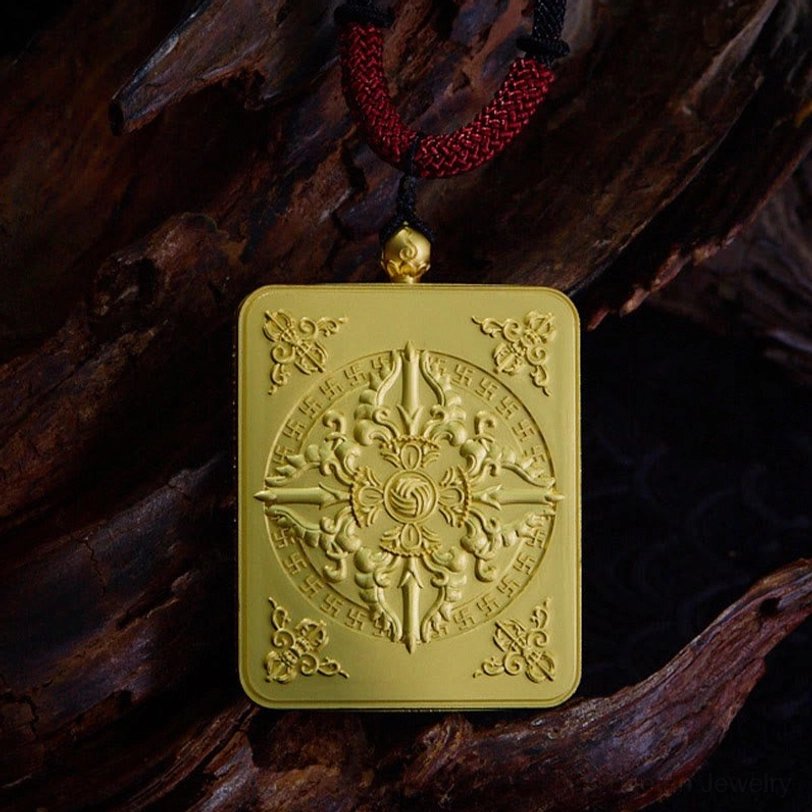 Embossed gold-toned Tibetan Buddhist amulet pendant featuring carved celestial deity symbolism and intricate details