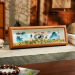 Feng Shui Bagua Koi Fish Yin Yang green crystal photo frame ornament displayed on traditional Chinese home desk with landscape art and decorative gravel