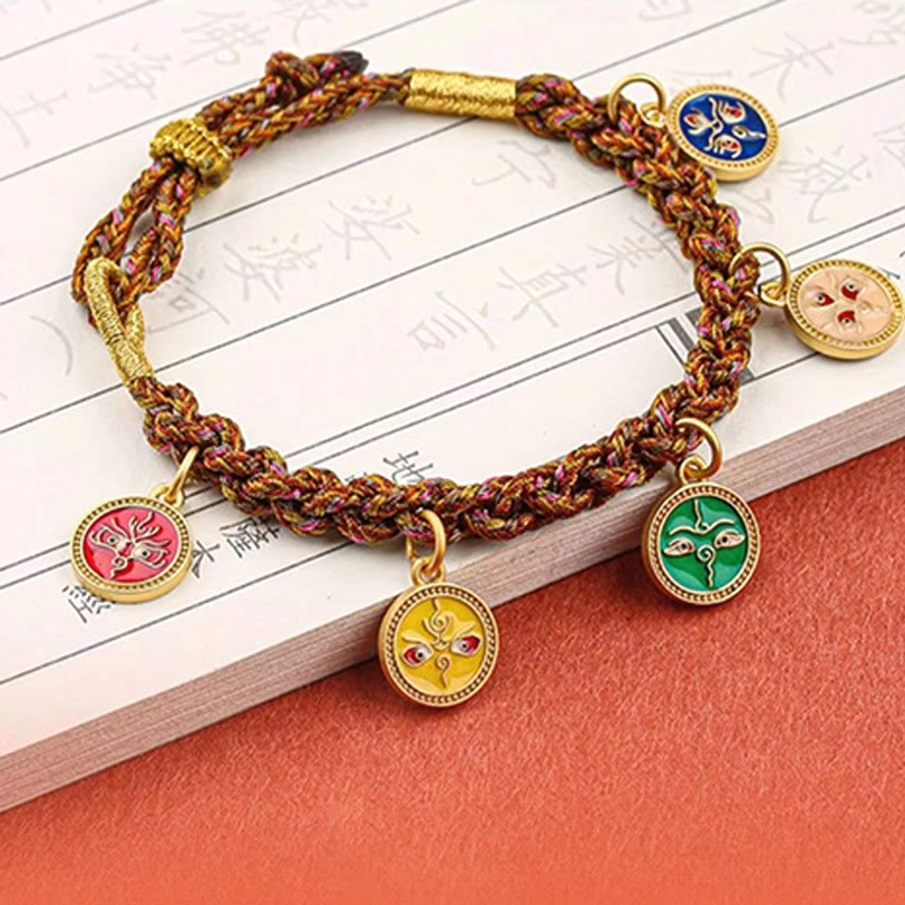 Five God of Wealth Tibetan bracelet displayed on ancient Chinese calligraphy background