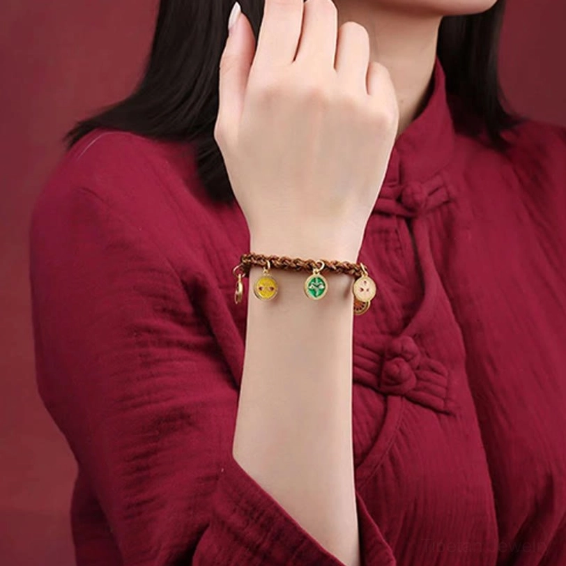 Tibetan prosperity bracelet on woman's wrist showing enamel pendant details