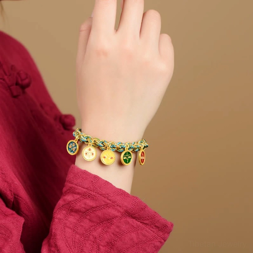 Tibetan Five God of Wealth bracelet worn on wrist with red clothing background, showing proper fit for average adult