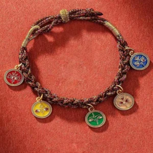 Five God of Wealth Tibetan braided bracelet flat lay showing five colored enamel pendants on woven cord