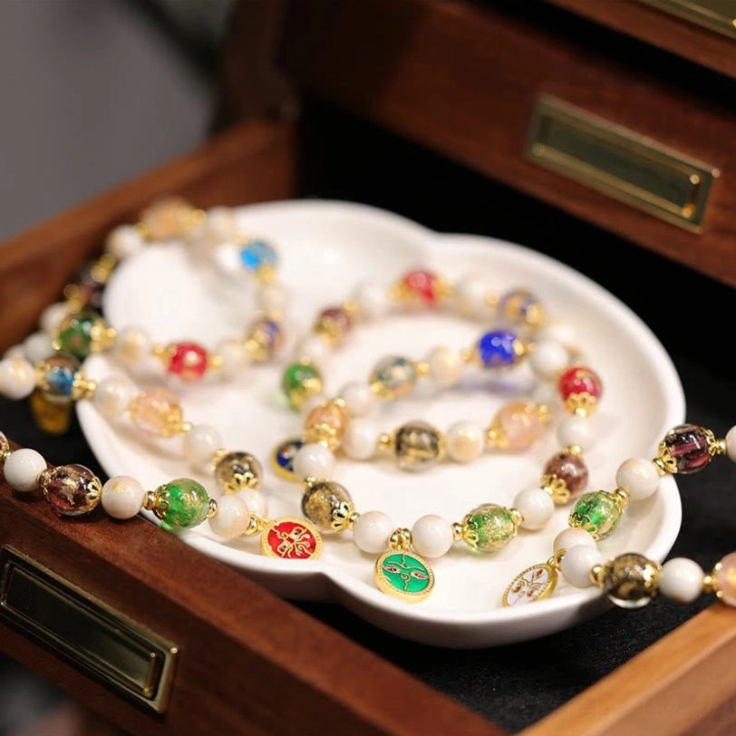 Five Gods of Wealth bracelet components displayed in wooden jewelry box showing loose beads, colorful enamel charms, and finished bracelet