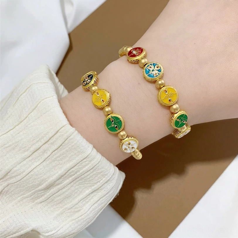 Five gods of wealth Tibetan prosperity bracelet detail shot emphasizing matte gold copper bead quality and enamel charm craftsmanship