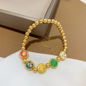Single five gods of wealth Tibetan prosperity bracelet with matte gold copper beads and colorful enamel charm beads on white cloth and brown paper box