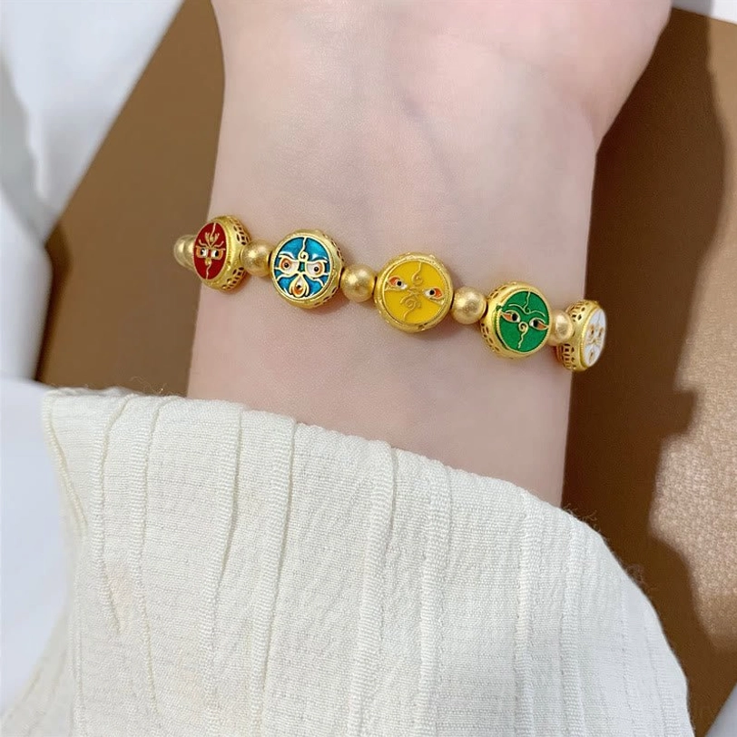 Single five gods of wealth Tibetan luck bracelet worn on wrist side view, clear display of enamel charm bead arrangement on white fabric backdrop