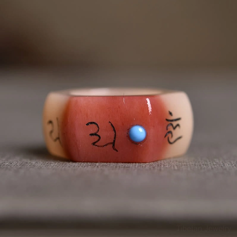 Multi-faceted camel bone ring with engraved Tibetan Buddhist mantras and central lapis lazuli inlay, geometric sacred design