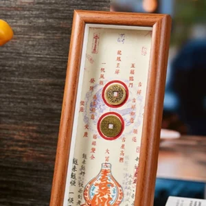Close-up of handcrafted fu frame with antique copper coins and chinese calligraphy panel