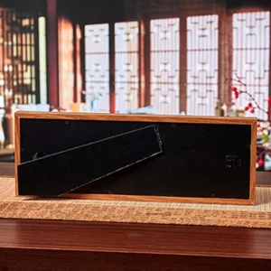 Back view of five-emperor coins fu frame showing black velvet backing and built-in tabletop display stand