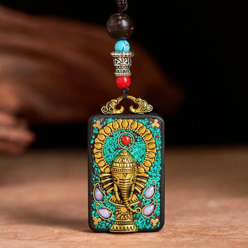 Ganesha ebony wood pendant with tiered metal beaded clasp and ornate gold hanging hardware