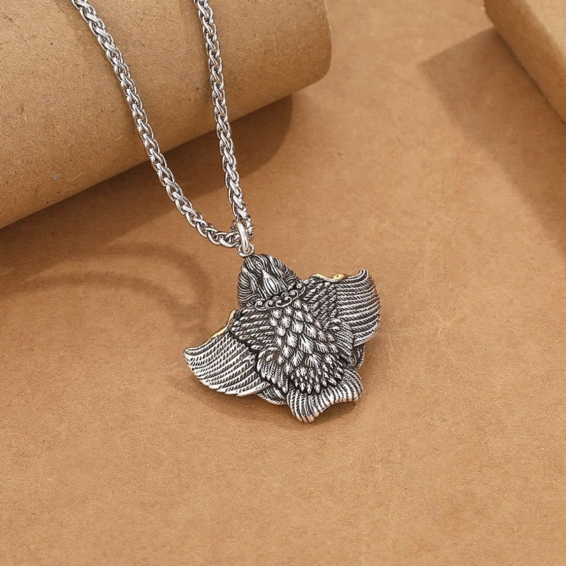 Tibetan Garuda Bird copper pendant with realistic feather carvings and antique silver tone finish, front oblique angle