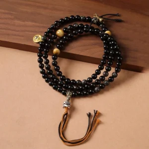 Silver Sheen Obsidian Garuda protection necklace hand-woven beads overhead view on wooden surface