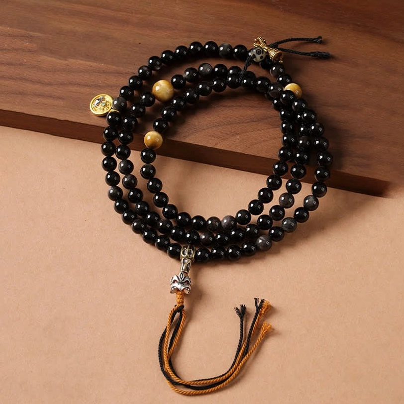 Silver Sheen Obsidian Garuda protection necklace hand-woven beads overhead view on wooden surface