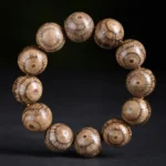 Gnetum wood beads protection bracelet overhead view with warm light brown radial grain pattern on dark background