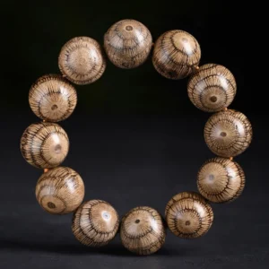 Gnetum wood beads protection bracelet overhead view with warm light brown radial grain pattern on dark background