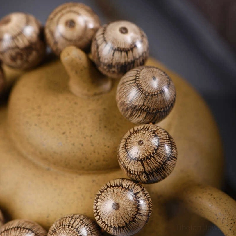 Detailed front view of Gnetum wood beads displaying natural grain surface patterns and smooth round finish