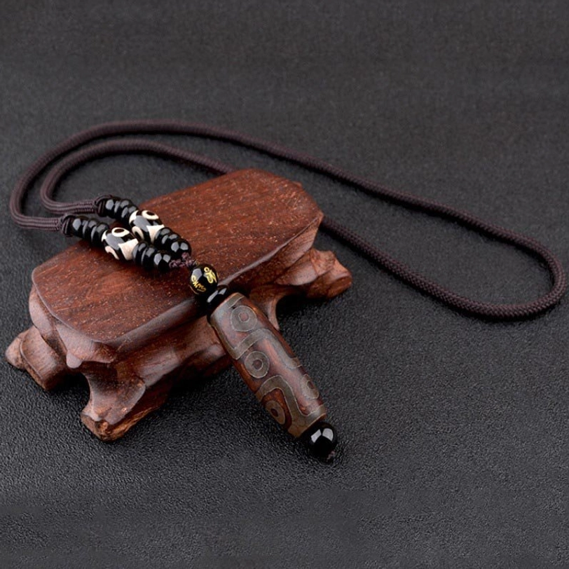 Gold-colored nine-eye Dzi bead necklace with hand-painted agate pendant and minimal decorative beads on wooden stand, Tibetan luxury pendant