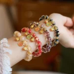 Multi-style gold Pi Xiu fortune bracelets with liuli glass beads and lucky charms, side wrist-worn view