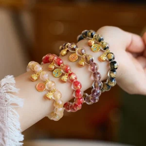 Multi-style gold Pi Xiu fortune bracelets with liuli glass beads and lucky charms, side wrist-worn view