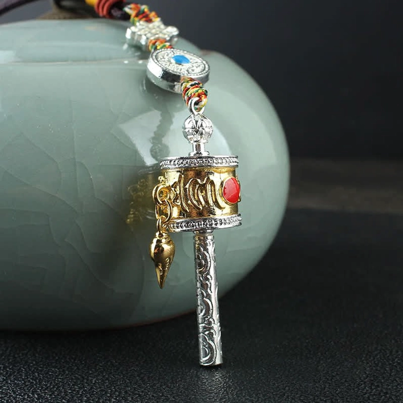 Gold prayer wheel hanging ornament with gold-silver mixed color finish, red gem decoration, carved metal handle attached to celadon ceramic pot