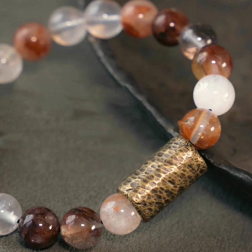 Gold rutilated quartz bracelet detail showing distinctive golden rutile needles within clear crystal matrix