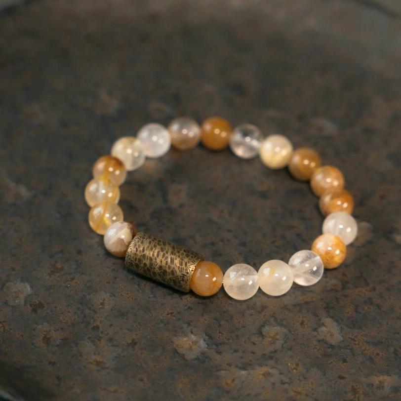 Gold rutilated crystal healing bracelet worn on wrist, close-up showing golden inclusions and natural formations