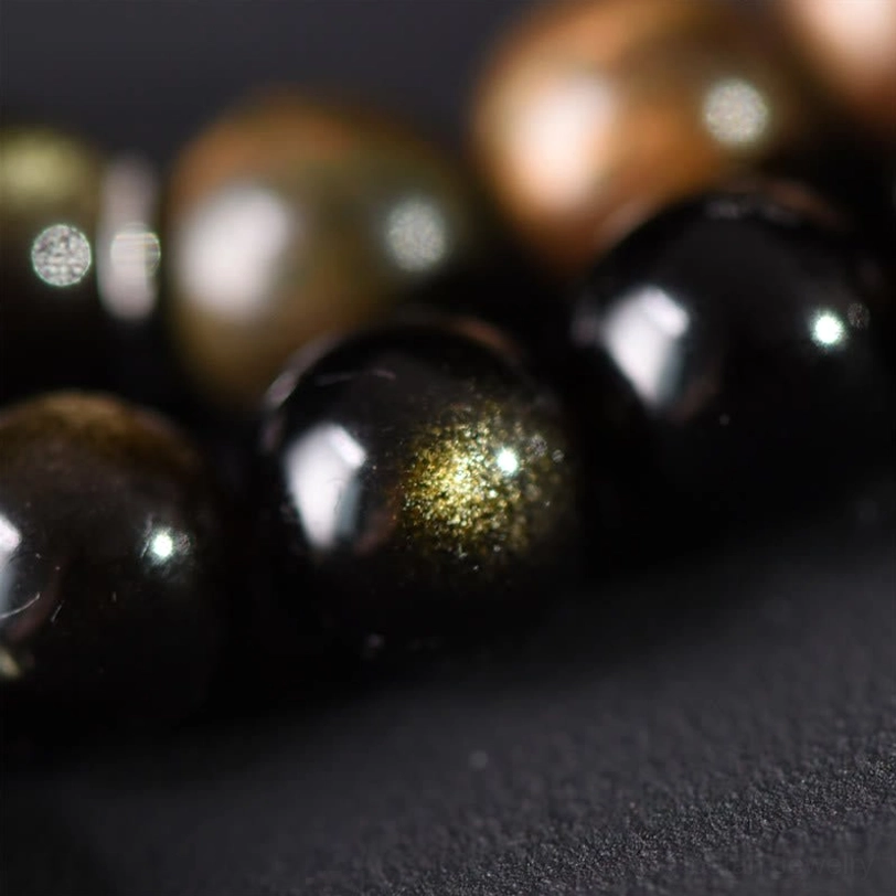 Gold sheen obsidian beads macro close-up showing lustrous golden inclusions