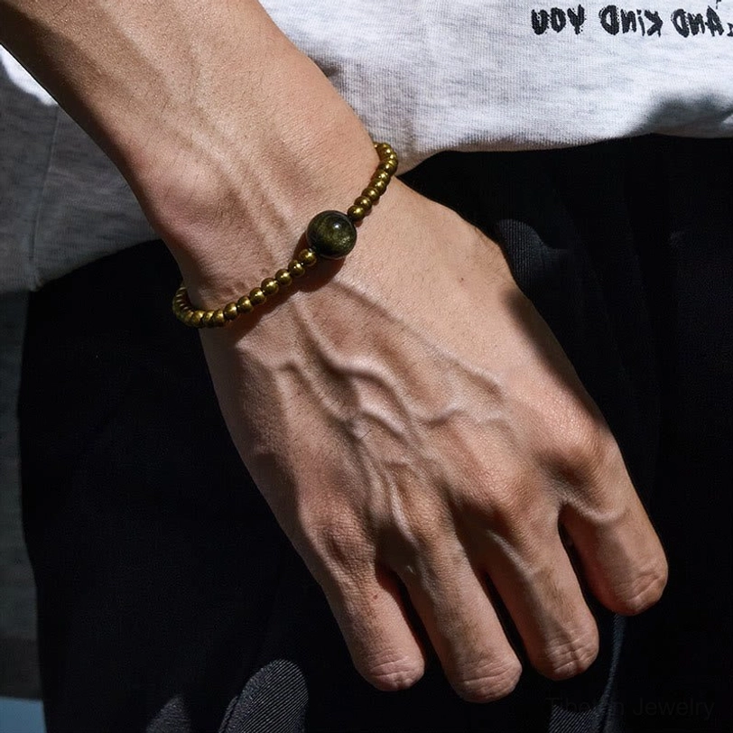 Tibetan obsidian bracelet worn on wrist close-up with copper brass accents