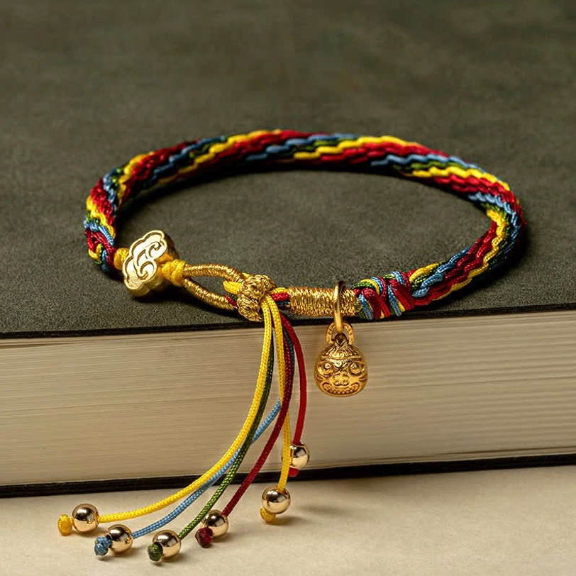 Gold Swallowing Beast Baby bracelet with rainbow woven rope, gold wishful clasp, and decorative tassel with bells