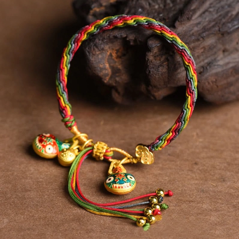 Gold swallowing beast luck knot bracelet rainbow braided rope with multiple enamel beast pendants and gold accents front view