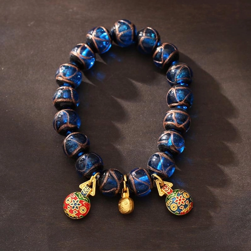 Full front display of gold swallowing beast blue Liuli glass wealth bracelet with decorative pendants