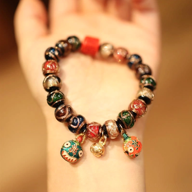 Gold Swallowing Beast Family Tibetan prosperity bracelet featuring enamel beast pendants and mixed stone beads on human hand