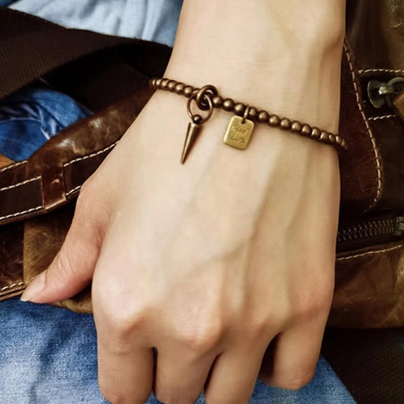 Copper prosperity bracelet fitted on male hand with leather bag and denim details for lifestyle context