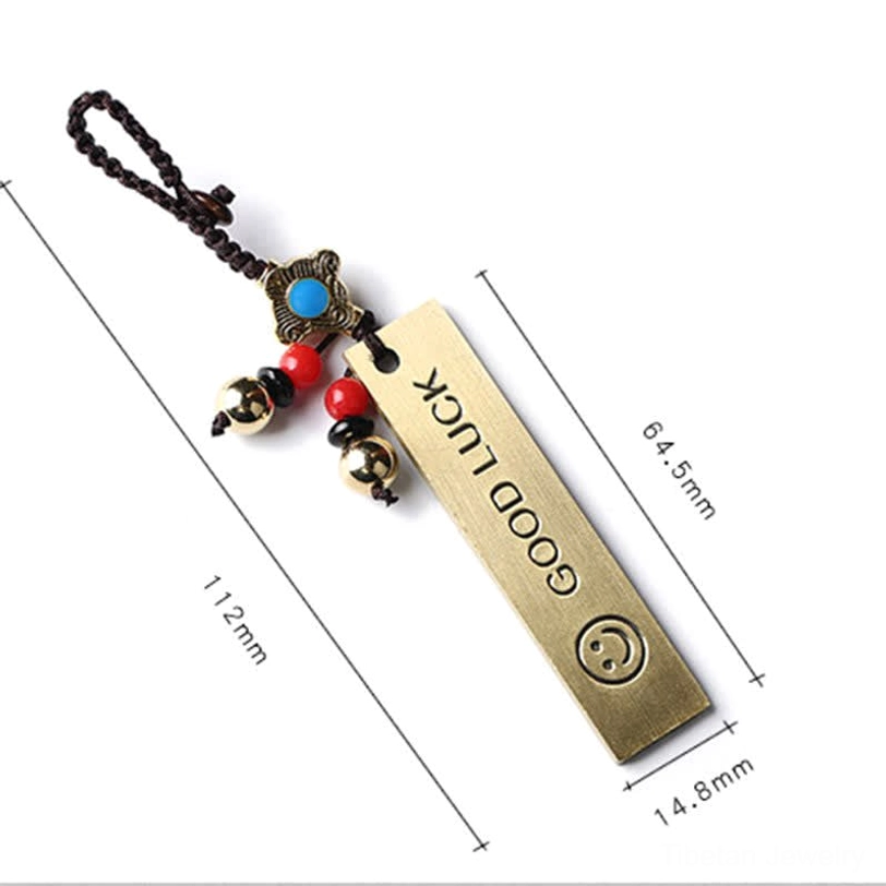 Good Luck brass tag keychain with engraved GOOD LUCK text and smiley face pattern, size reference measurements visible
