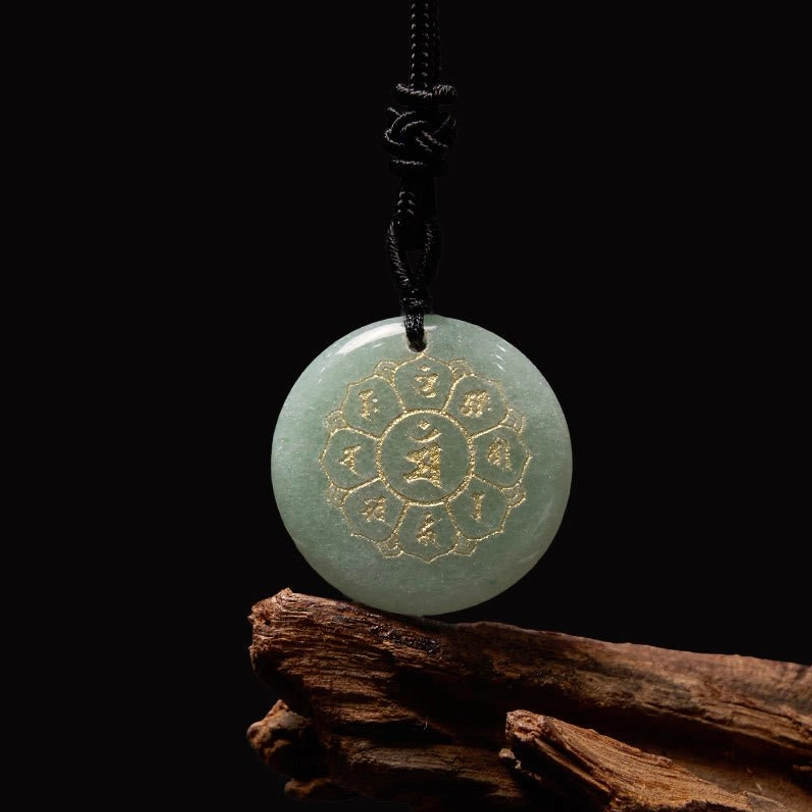 Green Aventurine Om Mani Padme Hum pendant with golden Sanskrit design on wooden background