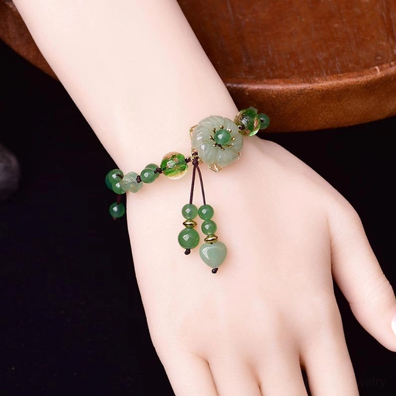 Green jade flower bracelet worn on wrist showing real wearing effect with dangling pendants and adjustable fit