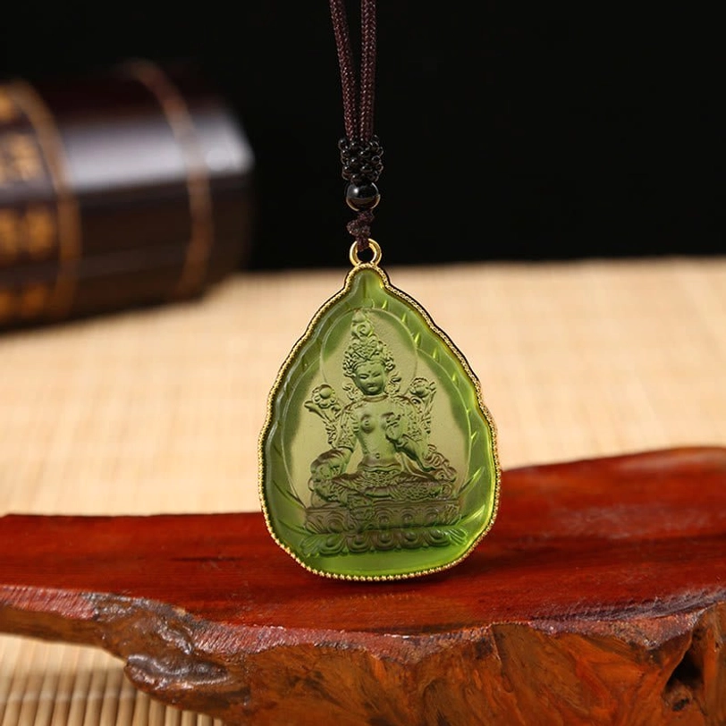 Green Tara Buddha translucent crystal pendant with detailed Tara engraving, gold trim, and black beaded cord