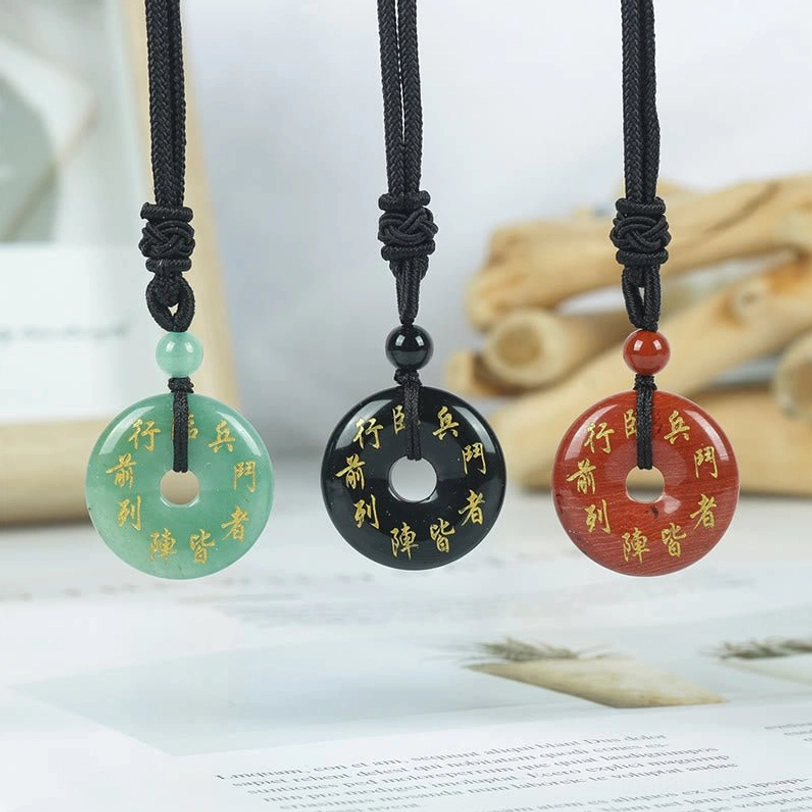 Three Green Tara mantra crystal necklaces in Black Obsidian, White Crystal, and Rose Quartz with golden Sanskrit engraving and braided black cords, flat lay display
