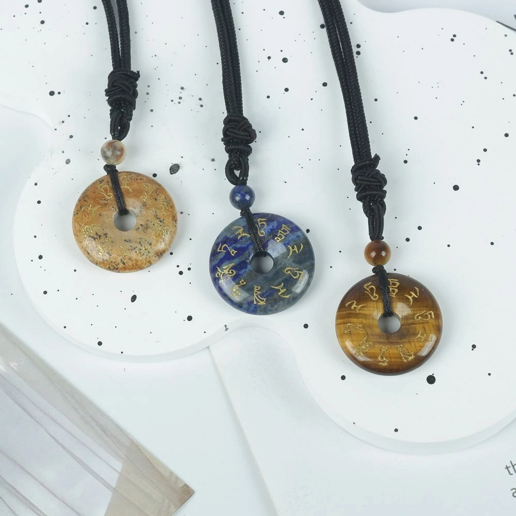 Multiple Green Tara mantra crystal pendants displayed together showing variety of natural stone colors and finishes