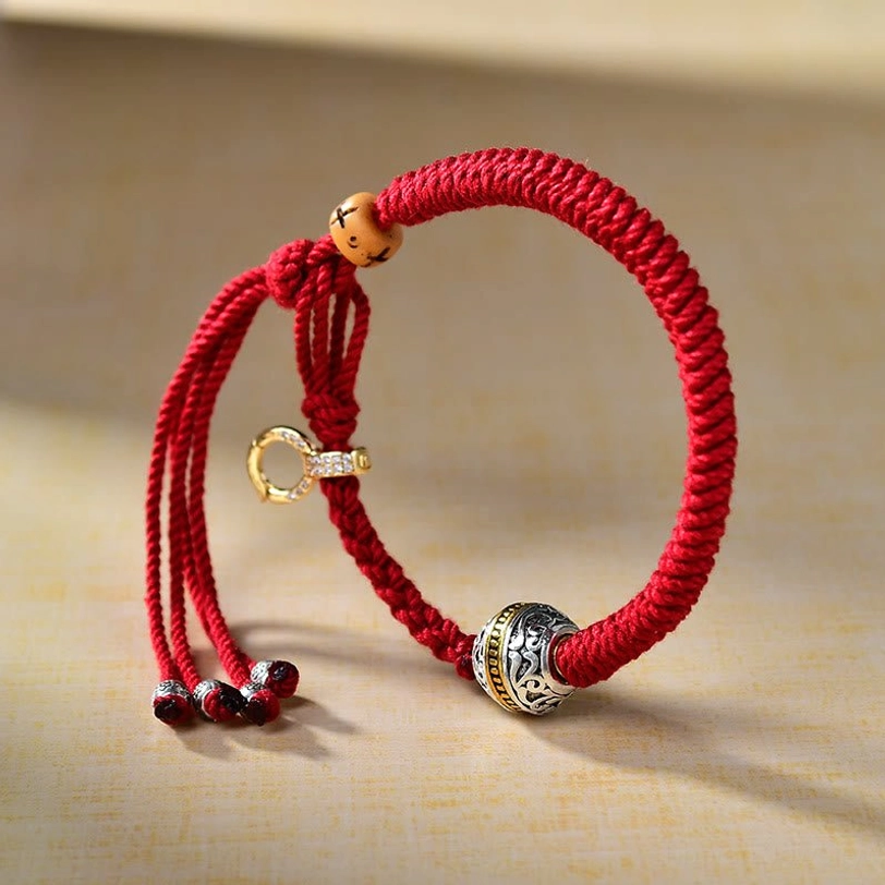 Green Tara protection bracelet front angle display with silver charm, red lucky string, wooden beads, and diamond-set clasp detail