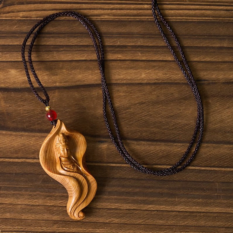 Complete Guanyin Avalokiteshvara wooden necklace - overhead view showing full black woven cord and compact light wood pendant