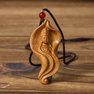 Guanyin wood pendant with black braided cord - left side angle showing carved details and red decorative bead