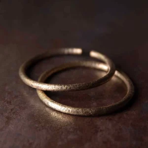 Stacked hammered copper adjustable cuff bracelets in antique bronze finish, flat lay overhead view