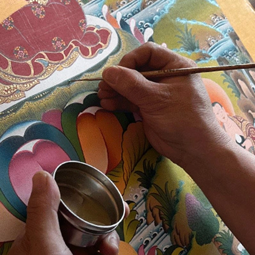 Hand-painted thangka detail showing vibrant colors and sacred Buddhist symbolism in traditional style