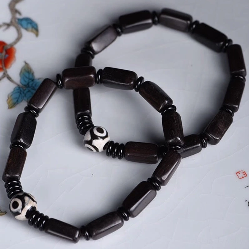Hand-painted two-eye Dzi bead detail on ebony wood balance bracelet showing authentic craftsmanship