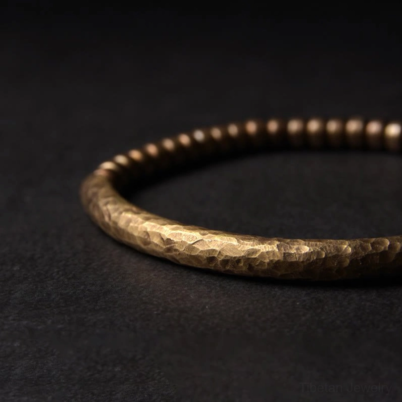 Close-up detail of copper brass bracelet side profile, highlighting hammered textured surface and warm bronze patina