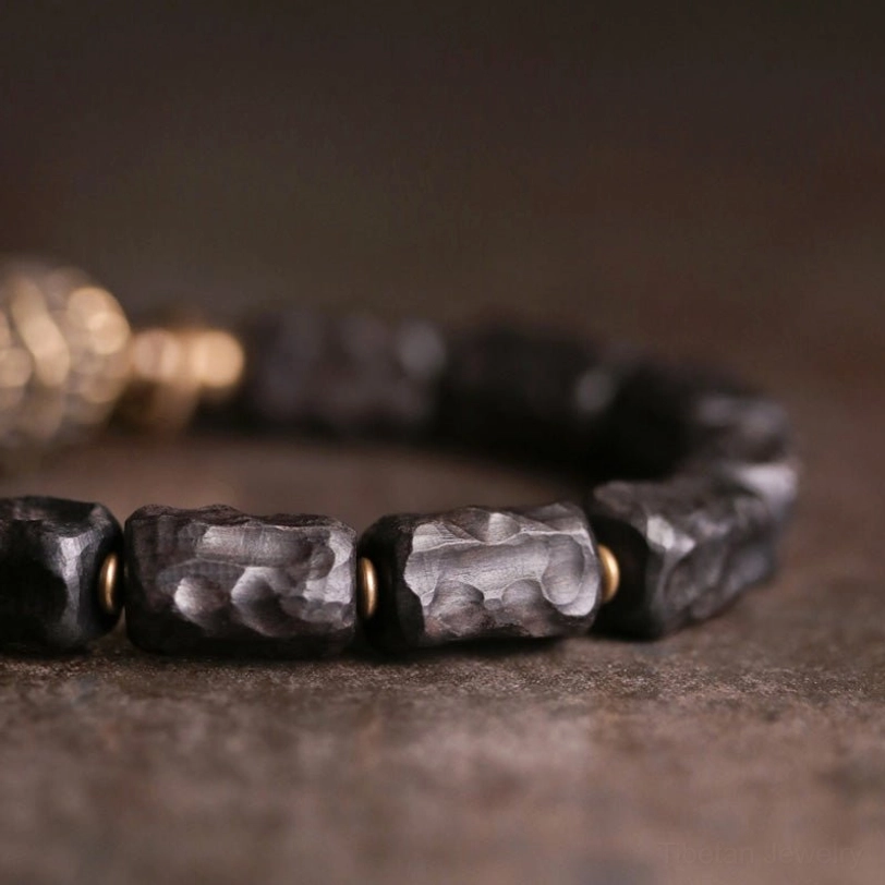 Macro close-up of ebony wood copper bracelet beads showing handcrafted texture and joinery