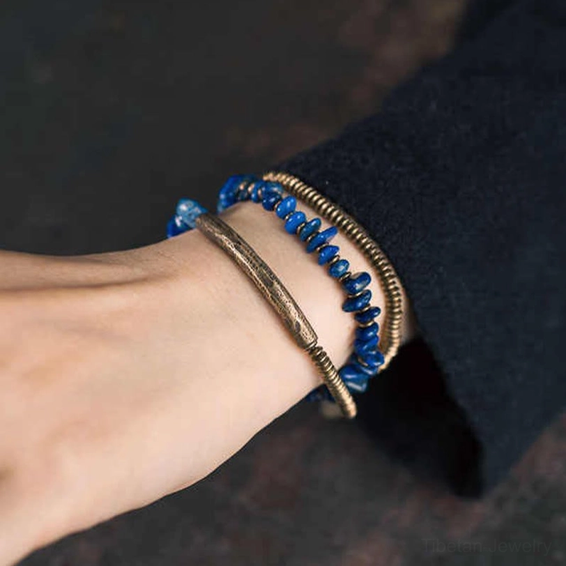 Handcrafted lapis lazuli triple wrap bracelet featuring natural stone chips and copper accents with elastic cord