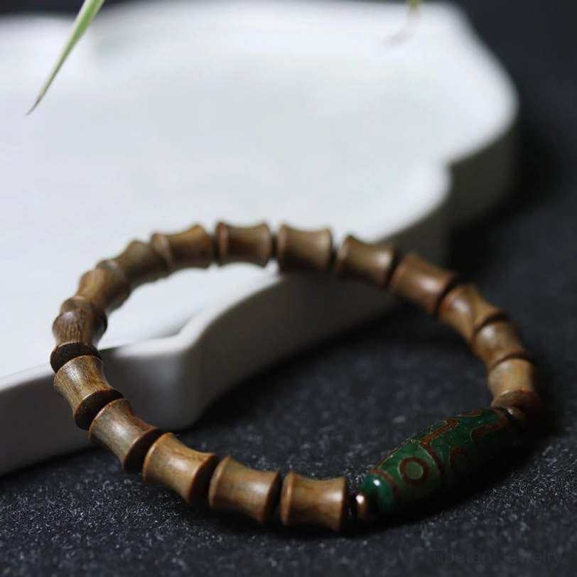 Handmade tibetan nine-eye dzi green sandalwood prosperity bracelet showing natural material variations and authentic craftsmanship